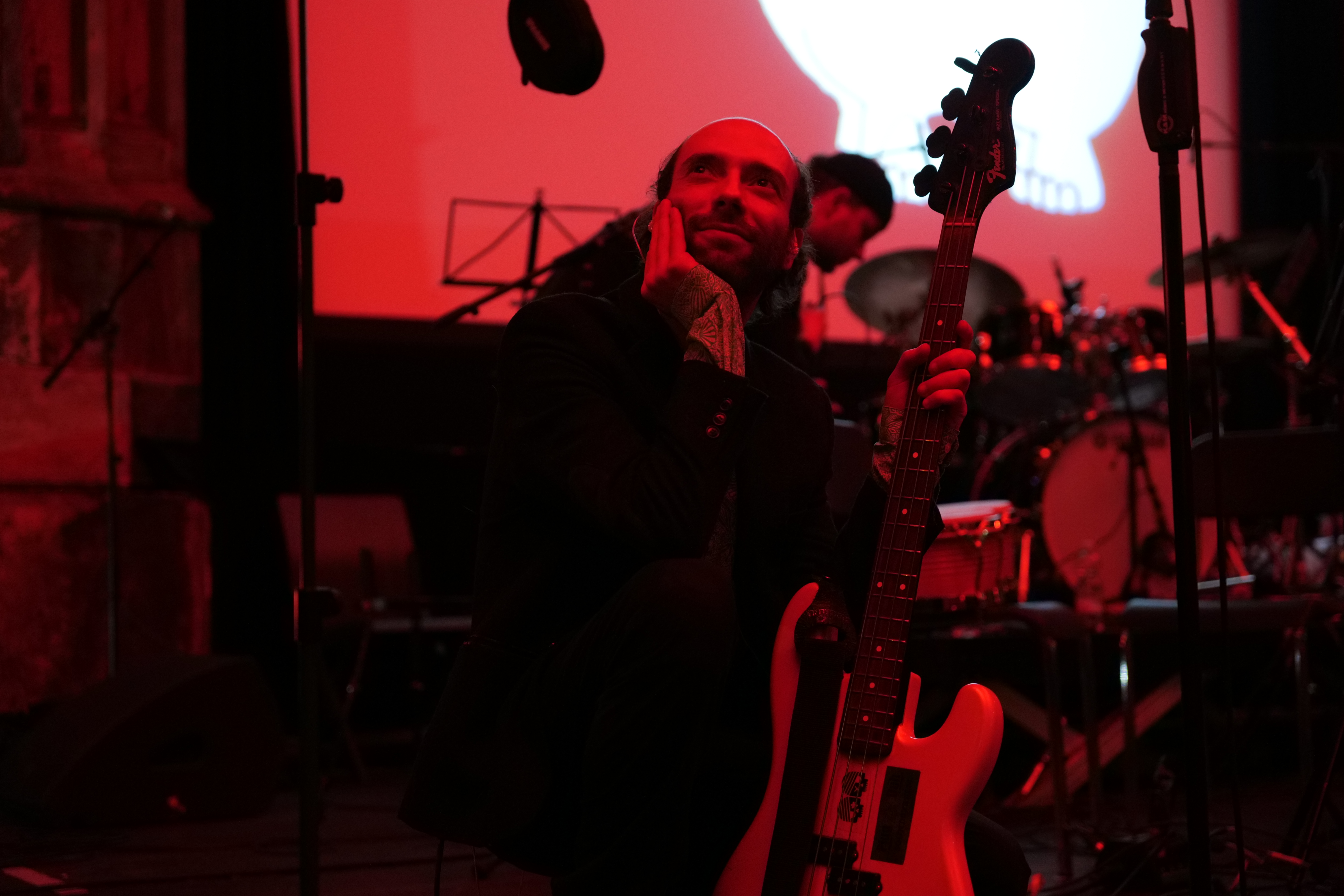 Bassist auf der Bühne unter rotem Bühnenlicht